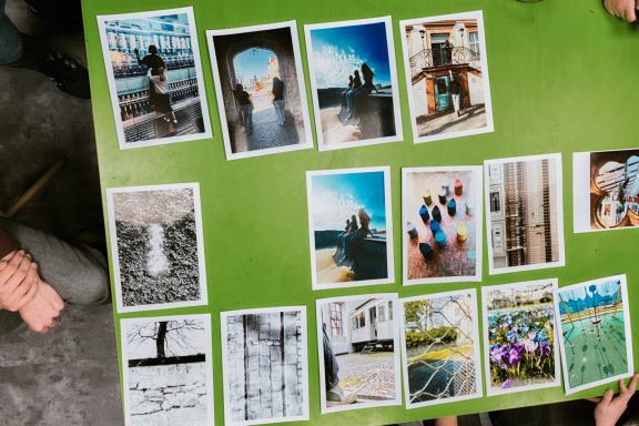 Fotografische Arbeiten zum Thema Demokratie Mehrere farbige und schwarzweiße Fotografien aus dem Workshop „Bilder der Demokratie“ liegen zur Auswahl und Vorbereitung der Ausstellung be
